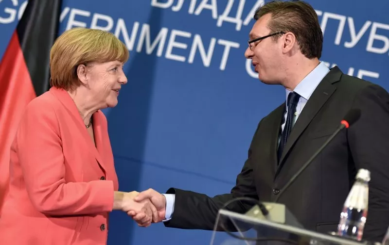Serbian Prime Minister Aleksandar Vucic (R) and German Chancellor Angela Merkel shake hands after their meeting in Belgrade, Serbia, on July 8, 2015. Angela Merkel is on a two-day visit to the Balkan States of Albania, Serbia and Bosnia, three countries whose ambitions to join the European Union have been complicated by the Greek crisis and their mutual rivalries.  AFP PHOTO / ANDREJ ISAKOVIC