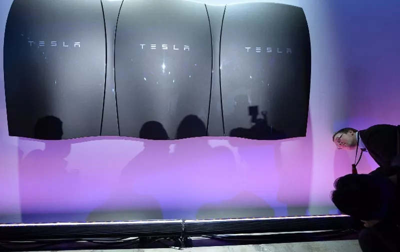 LOS ANGELES, CA - APRIL 30: Guests pose with the Powerwall unit after Elon Musk, CEO of Tesla unveiled suit of batteries for homes, businesses, and utilities at Tesla Design Studio April 30, 2015 in Hawthorne, California. Musk unveiled the home battery named Powerwall with a selling price of $3500 for 10kWh and $3000 for 7kWh and very large utility pack called Powerpack.   Kevork Djansezian/Getty Images/AFP