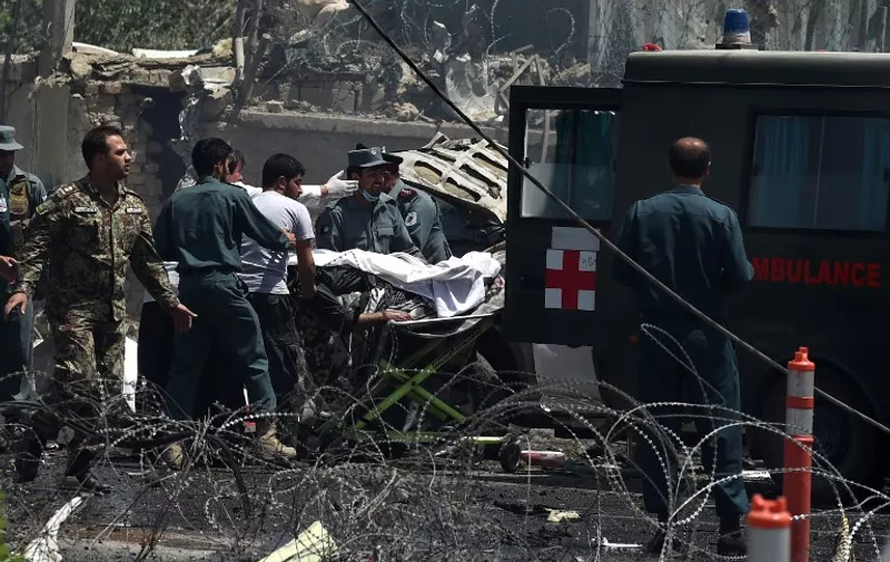 Afghan security forces carry a victim into a ambulance at the site of a huge blast near the entrance of the international airport, in Kabul on August 10, 2015.  At least five people were killed when a Taliban suicide car bomber struck near the entrance of Kabul's international airport, the latest in a wave of lethal bombings in the Afghan capital.  AFP PHOTO/ Wakil Kohsar