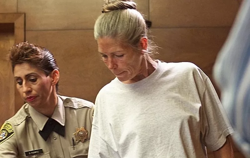 Corrections officer Sandra Fuentes (L) assists inmate Leslie Van Houten (R) as arrives for her parole hearing before members of the Board of Prison Terms 28 June 2002 at the California Institution for Women in Corona, California. Van Houten, 52, has served over 30 years in prison for her involvement in the Tate-LaBianca killings. AFP PHOTO/POOL/Damian DOVARGANES (Photo by DAMIAN DOVARGANES / AP / AFP)