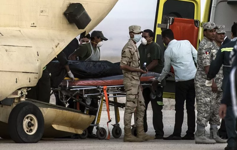 Egyptian paramedics load the corpses of Russian victims of a Russian passenger plane crash in the Sinai Peninsula, into a military plane at Kabret military air base by the Suez Canal on October 31, 2015. AFP PHOTO / KHALED DESOUKI
