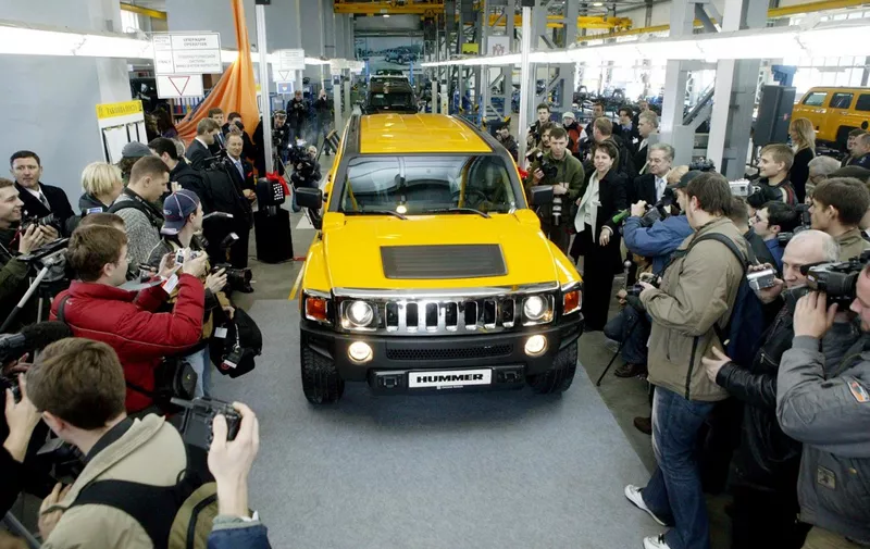 Photographers take pictures of a new Hummer-H3 vehicle at the automobile plant in Kaliningrad, 05 April 2006. A Russian factory in the Baltic enclave has begun assembling Hummer-H3 vehicles. The fact that cooperation with GM represents the first serious American investment in the region. Assembly of the off-road vehicle is the first in what is seen as a continuing series of undertakings by the giant automaker in Kaliningrad. The agreement on cooperation looks to the production of three other GM models at the plant. The Kaliningrad holding currently produces cars for the Korean firm KIA Motors and the German firm BMW.
 AFP PHOTO / STR (Photo by STRINGER / AFP)