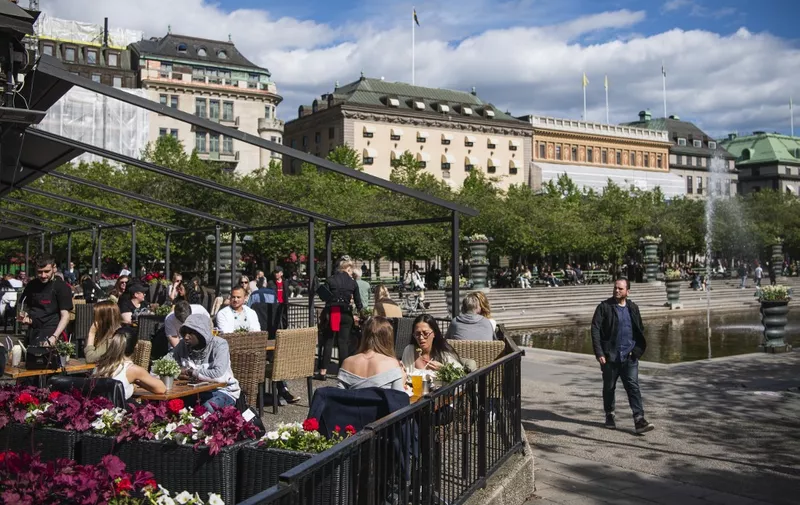 People sit in a restaurant in Stockholm on May 29, 2020, amid the coronavirus COVID-19 pandemic. - Sweden's two biggest opposition parties called Friday for an independent commission to be appointed within weeks to probe the country's response to the new coronavirus. (Photo by Jonathan NACKSTRAND / AFP)
