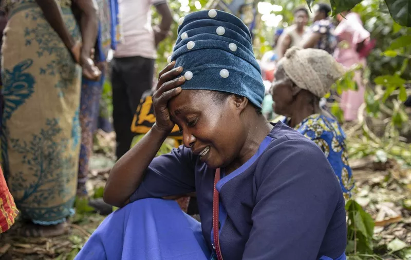 A woman mourns during the funeral of Florence Masika and Zakayo Masereka in Mpondwe on June 18, 2023. Florence and Zakayo have been killed near the border with the Democratic republic of Congo by fleeing assaliants who the authorities believe to belong to the Allied Democratic Forces (ADF), a militia based in DR Congo. Grieving families prepared to bury their dead in western Uganda on Sunday while others desperately searched for loved ones still missing after militants killed dozens of students in a school attack. Officials say at least 41 people, mostly students, were massacred on Friday in the worst attack of its kind in Uganda since 2010. Victims were hacked, shot and burned in the late-night raid on Lhubiriha Secondary School in Mpondwe, which lies less than two kilometres (1.2 miles) from the border with the Democratic Republic of Congo. (Photo by Stuart Tibaweswa / AFP)