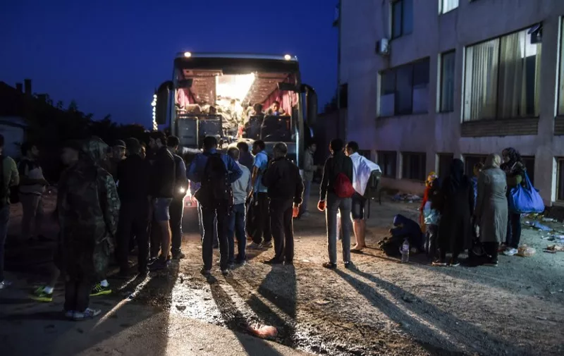 Migrants board a bus to Belgrade early in the morning in the town of Presevo, on August 24, 2015. Faced with what the bloc has called its worst refugee crisis since World War II, German Chancellor AngelaMerkel  and French President Francois Hollande will hold talks in Berlin on Monday in a bid to give a fresh impetus to the EU's response in dealing with the situation. AFP PHOTO/ARMEND NIMANI