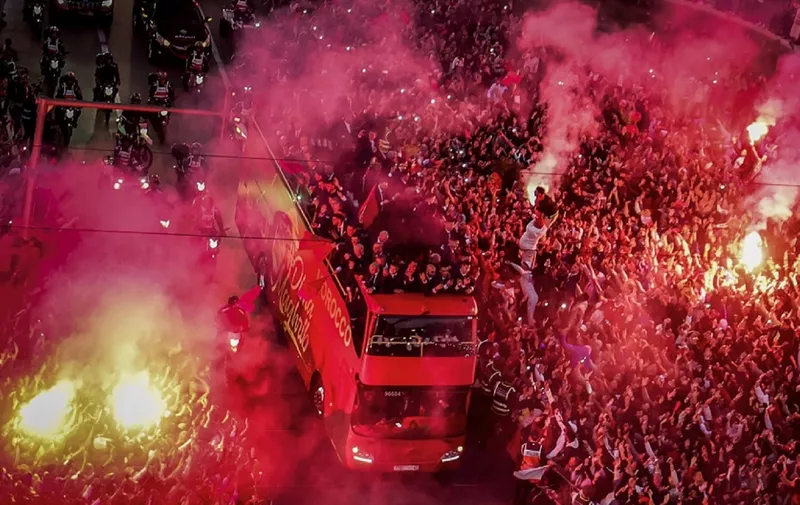 Supporters light flares and cheer as Morocco's national football team arrives to the center of the capital Rabat, on December 20, 2022, after the Qatar 2022 World Cup. (Photo by FADEL SENNA / AFP)