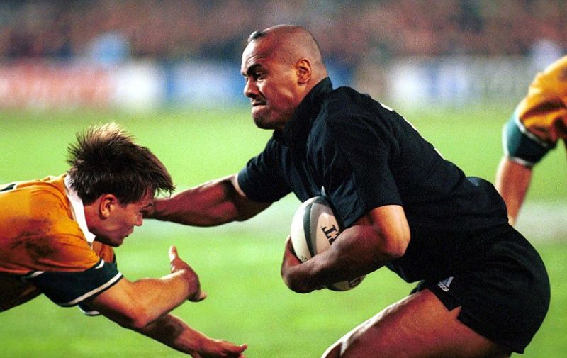 New Zealand's Jonah Lomu (R) fends off Australia's Matthew Burke during thei rugby union test match in Auckland 24 July 1999. New Zealand won 34-15.  AFP PHOTO