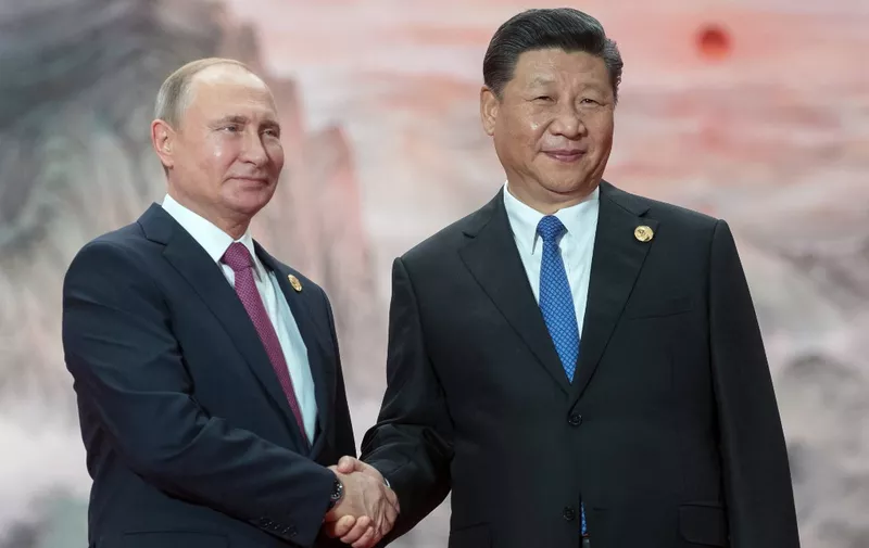 Russian President Vladimir Putin (l) shakes hands with President of the Peoples Republic of China Xi Jinping during a welcoming ceremony at the Shanghai Cooperation Organization (SCO) Council of Heads of State in Qingdao on June 10, 2018. (Photo by Sergei GUNEYEV / Sputnik / AFP)