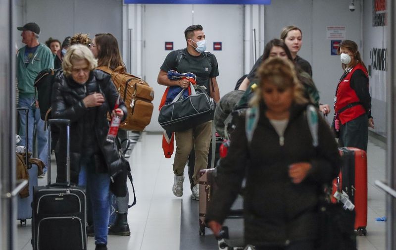 (FILES) In this file photo taken on March 15, 2020, travelers arrive at the international terminal of the O'Hare Airport in Chicago, Illinois. - Air passengers bound for the US will require a negative Covid-19 test within three days of their departure, the Centers for Disease Control and Prevention (CDC) said on January 12, 2021. "Testing does not eliminate all risk but when combined with a period of staying at home and everyday precautions like wearing masks and social distancing, it can make travel safer," said CDC Director Robert Redfield. (Photo by KAMIL KRZACZYNSKI / AFP)