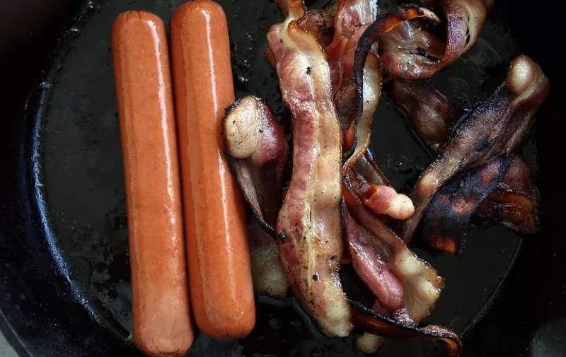MIAMI, FL - OCTOBER 26: In this photo illustration, processed meats, including hotdogs and bacon, cook in a frying pan on October 26, 2015 in Miami, Florida. A report released today by the World Health Organisation's International Agency for Research on Cancer announced that eating processed meat can lead to colorectal cancer in humans even as it remains a small chance but rises with the amount consumed. (Photo illustration by Joe Raedle/Getty Images/AFP