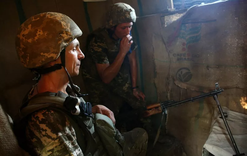 Ukrainian servicemen rests after clashes along the front line with Russia backed separatists, near the small town of Krasnogorivka, in the Donetsk region on July 20, 2021. (Photo by Anatolii STEPANOV / AFP)