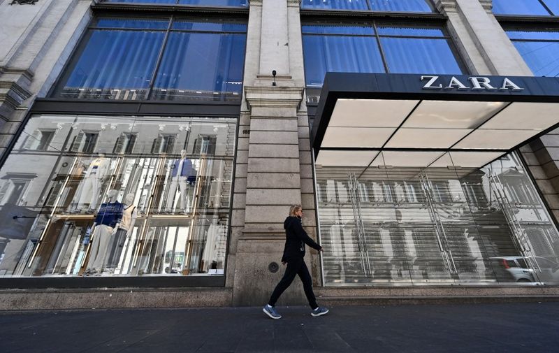 A man walks by a closed Zara shop in Rome, on March 15, 2021, as three-quarters of Italians entered a strict lockdown as the government put in place restrictive measures to fight the rise of COVID-19 infections. (Photo by Andreas SOLARO / AFP)