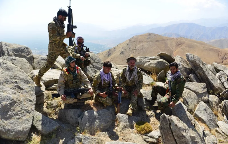 Afghan resistance movement and anti-Taliban uprising forces take rest as they patrol on a hilltop in Darband area in Anaba district, Panjshir province on September 1, 2021. - Panjshir -- famous for its natural defences never penetrated by Soviet forces or the Taliban in earlier conflicts -- remains the last major holdout of anti-Taliban forces led by Ahmad Massoud, son of the famed Mujahideen leader Ahmed Shah Massoud. (Photo by Ahmad SAHEL ARMAN / AFP)