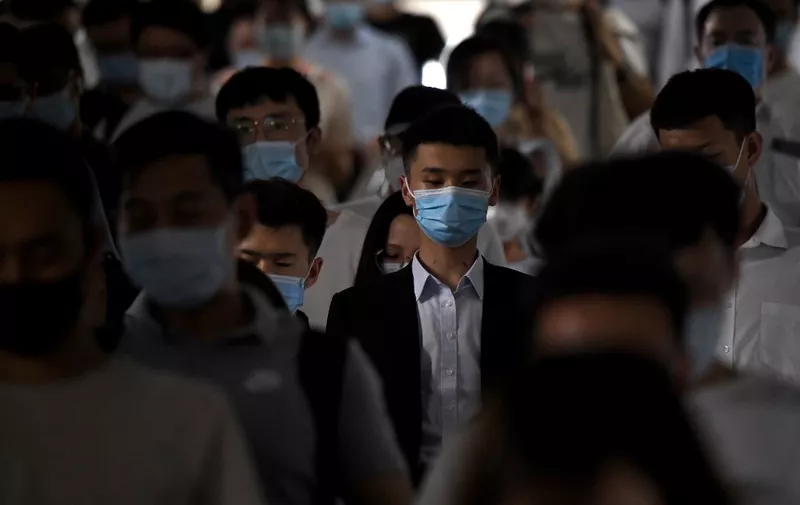 Passengers wearing face masks walk through a train station during rush hour in Beijing on June 15, 2020. (Photo by Noel Celis / AFP)