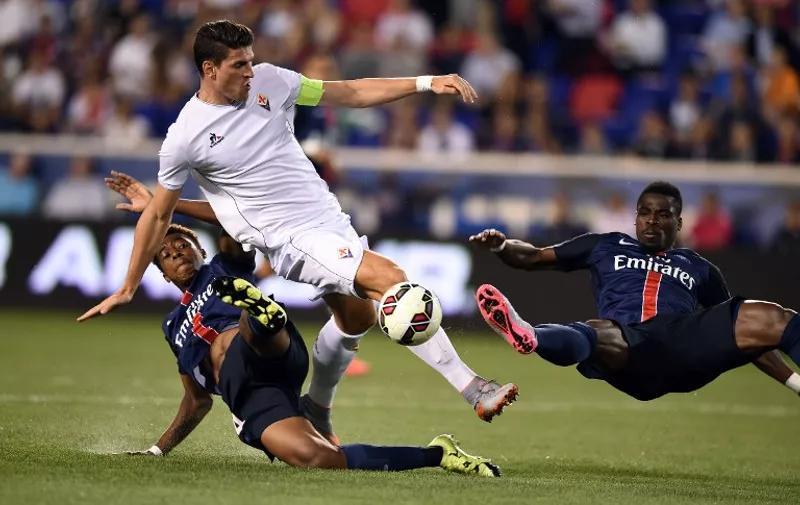 Fiorentina's forward from Germany Mario Gomez (C) is challenged by Paris' French midfielder Neeskens Kebano (L) and Surge Aurier during their International Champions Cup match at the Red Bull Arena in Harrison, New Jersey, on July 21, 2015. AFP PHOTO/JEWEL SAMAD