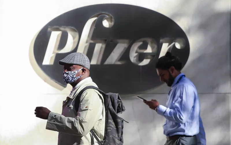 People walk by the Pfizer world headquarters in New York on November 9, 2020. - Pfizer stock surged higher on November 9, 2020 prior to the opening of Wall Street trading after the company announced its vaccine is "90 percent effective" against Covid-19 infections. The news cheered markets worldwide, especially as coronavirus cases are spiking, forcing millions of people back into lockdown. (Photo by Kena Betancur / AFP)