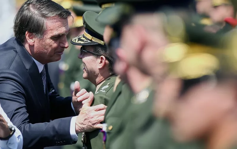 Brazilian President Jair Bolsonaro (L) speaks with a military man during a ceremony for the Soldier Day at the Brazilian Army Headquarters in Brasilia, Brazil, on August 23, 2019. - Brazilian President Jair Bolsonaro says he is inclined to send the army to help fight fires in the Amazon that have scared people around the world. (Photo by Sergio LIMA / AFP)