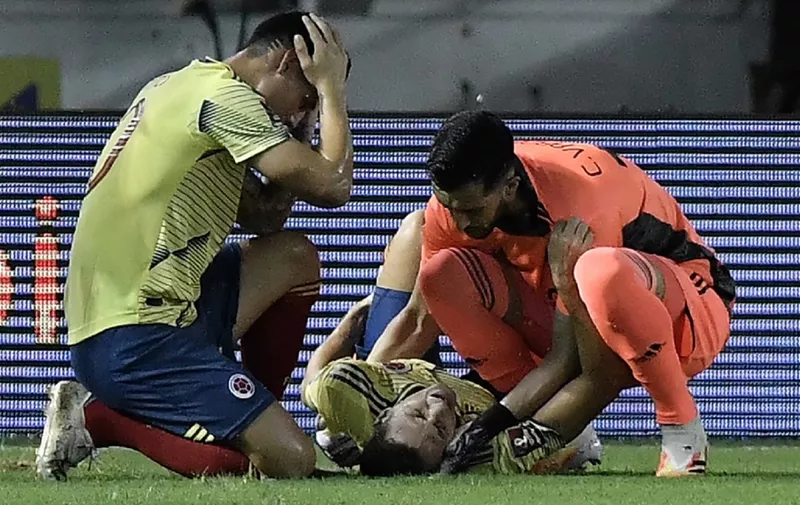 Colombia's Santiago Arias lies injured during the 2022 FIFA World Cup South American qualifier football match against Venezuela at the Roberto Melendez Metropolitan Stadium in Barranquilla, Colombia, on October 9, 2020, amid the COVID-19 novel coronavirus pandemic. (Photo by Gabriel Aponte / POOL / AFP)