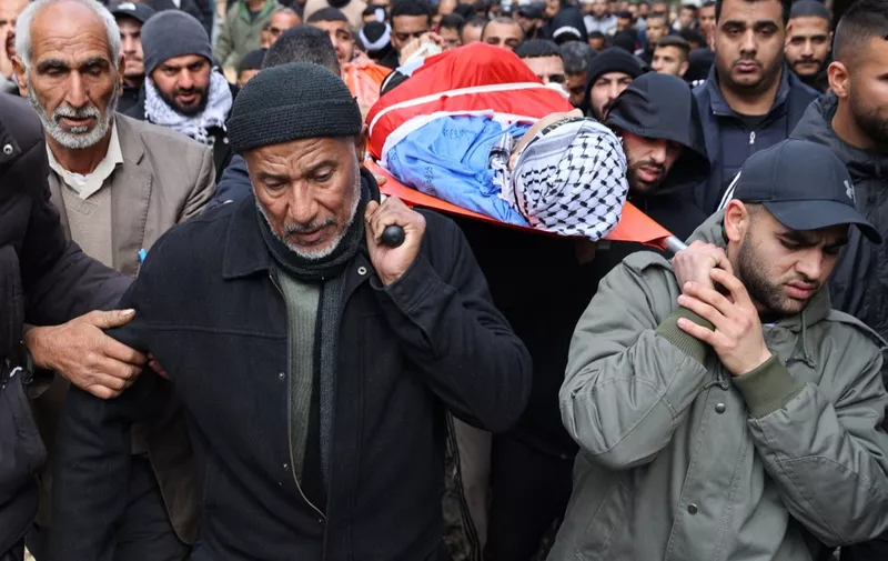 Palestinian mourners carry the body of Nabil Mohammed Amer, 19, during his funeral at the Tulkarm camp for Palestinian refugees on February 19, 2024, a day after he was killed in an Israeli raid on the camp amid a surge of violence in the Israel-occupied West Bank while battles continue between Israel and Hamas militants in the Gaza Strip. (Photo by Jaafar ASHTIYEH / AFP)