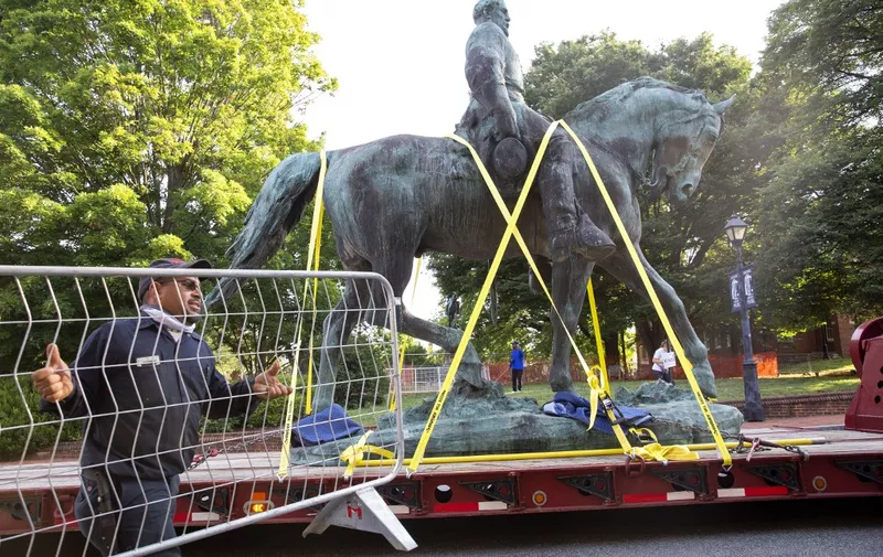 Workers remove the statue of Confederate General Robert E. Lee from a park in Charlottesville, Virginia on July 10, 2021. - The statue of Confederate General Robert E. Lee was removed and taken to storage, years after the threat of the removal inspired a violent 2017 rally that left a woman dead and many injured. (Photo by Ryan M. Kelly / AFP)