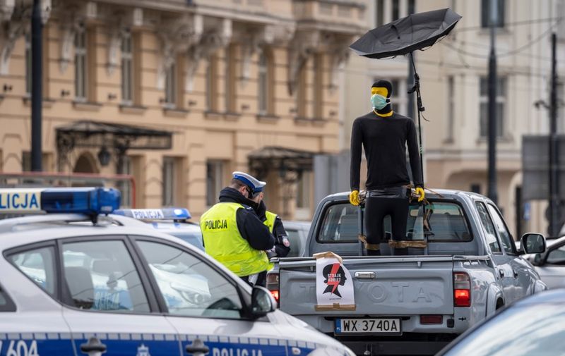 Policemen stand next to a pick-up car during a protest of Polish women's rights activists using their cars and bicycles to block central Warsaw against a draft legislation that would ban the abortion of foetuses with congenital birth defects, on April 14, 2020. - Poland's parliament is expected to debate fresh efforts to further tighten what is already one of Europe's most restrictive abortion laws. (Photo by Wojtek RADWANSKI / AFP)
