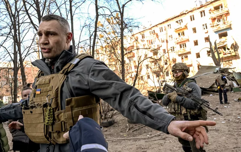 Kyiv's mayor Vitali Klitschko holds people away from a five-storey residential building that partially collapsed after a shelling in Kyiv on March 18, 2022, as Russian troops try to encircle the Ukrainian capital as part of their slow-moving offensive. - Authorities in Kyiv said one person was killed early today when a downed Russian rocket struck a residential building in the capital's northern suburbs. They said a school and playground were also hit. (Photo by Sergei SUPINSKY / AFP)