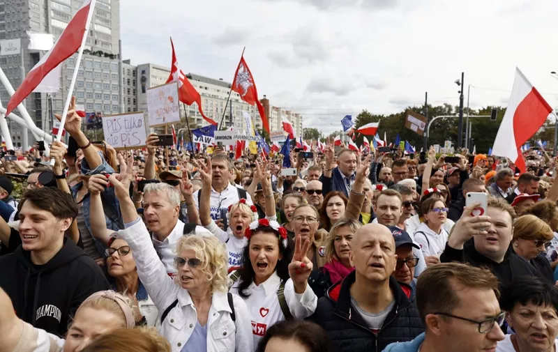Demonstrators react as Polish opposition leader, former premier and head of the centrist Civic Coalition bloc, Donald Tusk (not pictured) addresses participants of a rally in Warsaw on October 1, 2023. Polish opposition leader Donald Tusk said "hundreds of thousands" of protesters had gathered in central Warsaw on October 1 to oppose the conservative government ahead of general elections on October 15. Called by Tusk, the former premier and head of the centrist Civic Coalition bloc, the rally sought to mobilise the electorate for the crunch vote. (Photo by Wojtek Radwanski / AFP)