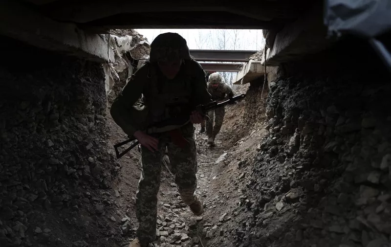 Ukrainian soldiers walk through a tunnel of a trench on the front line with Russian troops in Lugansk region on April 11, 2022. (Photo by Anatolii STEPANOV / AFP)