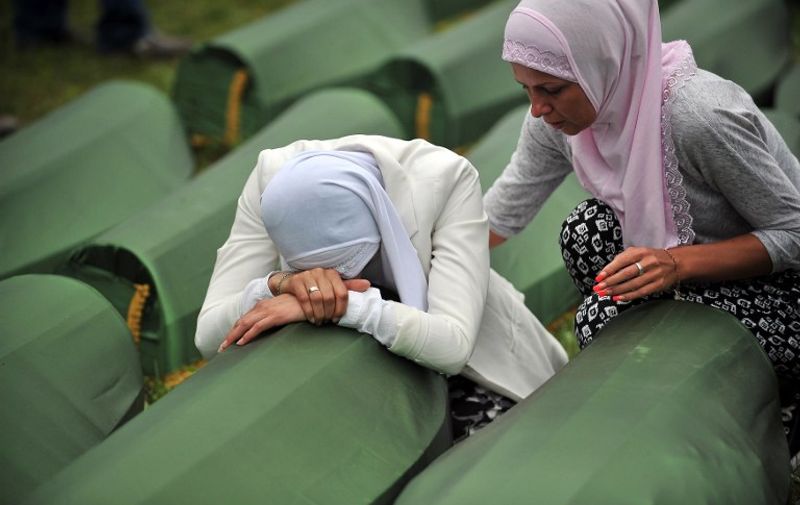 A Bosnian Muslim woman, survivor of the Srebrenica 1995 massacre cries by the coffin of a relative, layed out among others at the memorial cemetery in the village of Potocari near the eastern-Bosnian town of Srebrenica, on July 11, 2014. Several thousand people gathered on July 11 in Srebrenica for the 19th anniversary of the massacre of some 8,000 Muslim males by ethnic Serbs forces, Europe's worst atrocity since World War II. A total of 175 newly-identified massacre victims will be laid to rest after a commemoration ceremony held in Potocari, just outside the ill-fated Bosnian town. AFP PHOTO / ELVIS BARUKCIC