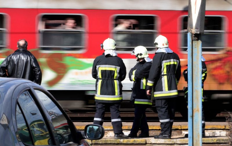Firefighters watch a passing passenger train as they guard the accident scene where a freight locomotive smashed into a passenger train in a station in the eastern Slovakia town of Spisska Nova Ves on April 1, 2010 leaving 3 people dead and 10 injured.AFP PHOTO/JOE KLAMAR (Photo by JOE KLAMAR / AFP)
