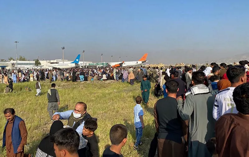 Afghans crowd at the airport as they wait to leave from Kabul on August 16, 2021. (Photo by Shakib Rahmani / AFP)