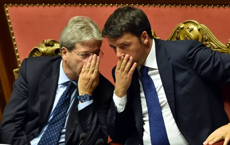 Italian Prime Minister Matteo Renzi (R) speaks with Foreign Affairs Minister Paolo Gentiloni after his speech focused on the next European Council, on October 14, 2015 at the Senate in Rome.  AFP PHOTO / ALBERTO PIZZOLI / AFP PHOTO / ALBERTO PIZZOLI