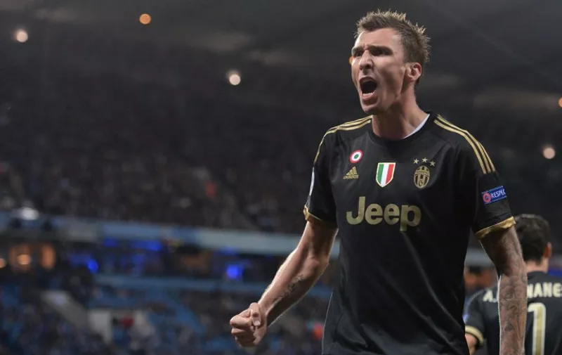Juventus' forward from Croatia Mario Mandzukic celebrates after scoring during a UEFA Champions League group stage football match between Manchester City and Juventus at the Etihad stadium in Manchester, north-west England on September 15, 2015.    AFP PHOTO / OLI SCARFF
