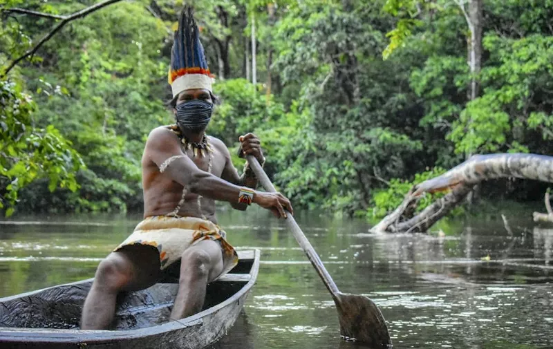 A Colombian Huitoto indigenous man sails on a raft along the Takana river in Leticia, department of Amazonas, Colombia on May 20, 2020 during the COVID-19 coronavirus pandemic. (Photo by Tatiana de Nevó / AFP)