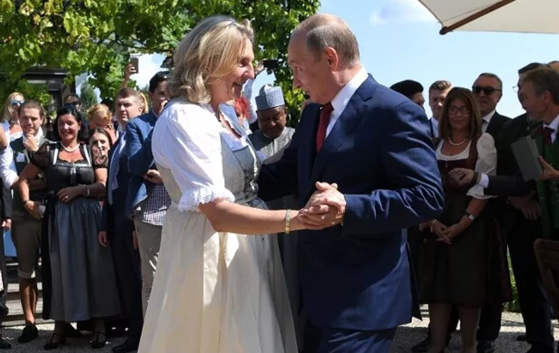 Austrian Foreign Minister Karin Kneissl and Russian President Vladimir Putin dance during her wedding on August 18, 2018 in Gamlitz, Styria, Austria. (Photo by Roland SCHLAGER / various sources / AFP)