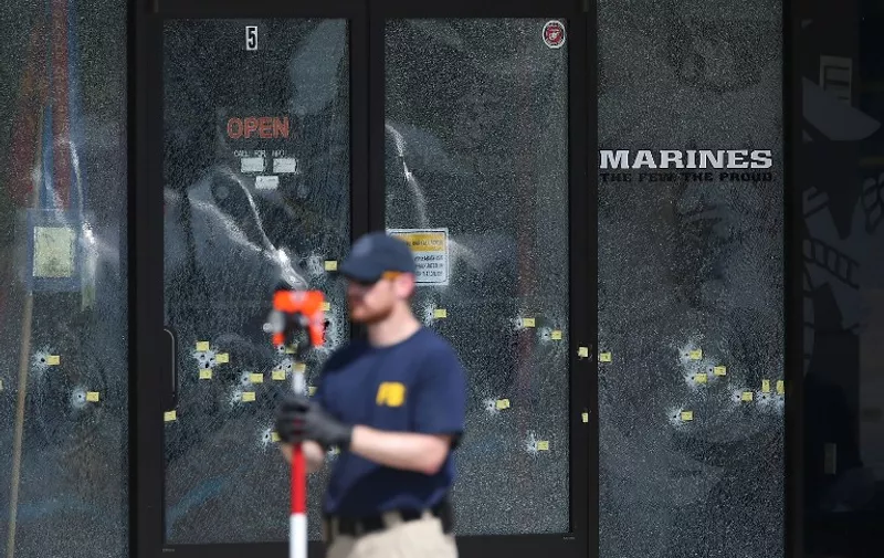 CHATTANOOGA, TN - JULY 17: A member of the FBI Evidence Response Team works near the bullet riddled doors as he investigates the shooting at the Armed Forces Career Center/National Guard Recruitment Office on July 17, 2015 in Chattanooga, Tennessee. According to reports, Mohammod Youssuf Abdulazeez, 24, opened fire on the military recruiting station at the strip mall and then drove to an operational support center operated by the U.S. Navy more than seven miles away and killed four United States Marines there.   Joe Raedle/Getty Images/AFP
