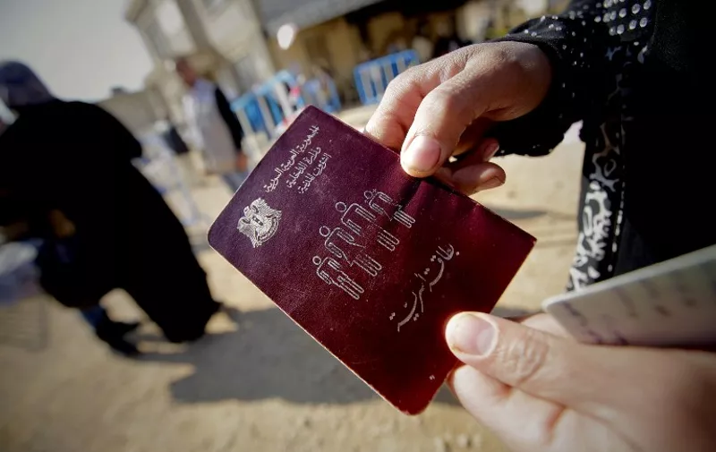 A Syrian woman shows her passeport as families, who fled recent violence in the mountainous Qalamoun region, wait to be registered by the United Nations High Commissioner for Refugees (UNHCR) on November 19, 2013 in Arsal in the Lebanese Bekaa valley. The fighting in Qara in the Qalamoun region sent at least 1,700 families streaming across the border into Lebanon, which is already hosting more than 800,000 Syrian refugees and has suffered from rising unrest linked to the conflict in its larger neighbour. Syrian troops captured the village of Qara on November 19, 2013.       AFP PHOTO/JOSEPH EID
