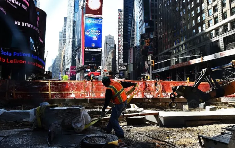 A laborer works on a footpath and road way construction site in Times Square on October 8, 2014 in New York. The September US employment report showed a welcome rebound in job growth after August's worrisome slump, taking the monthly job creation average so far this year to 227,000 and pushing the jobless rate down to 5.9 percent, a six-year low. AFP PHOTO/Jewel Samad / AFP PHOTO / JEWEL SAMAD