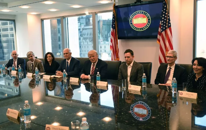 (L-R) Amazon's chief Jeff Bezos, Larry Page of Alphabet, Facebook COO Sheryl Sandberg, Vice President elect Mike Pence, President-elect Donald Trump, Peter Thiel, co-founder and former CEO of PayPal, Tim Cook of Apple and Safra Catz of Oracle attend a meeting at  Trump Tower December 14, 2016 in New York. / AFP PHOTO / TIMOTHY A. CLARY