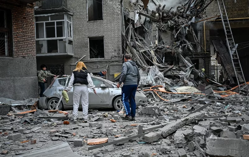 Local residents stand amid the rubble of an apartment after it was hit by a missile strike in Kharkiv, on September 6, 2022, amid the Russian invasion of Ukraine. (Photo by SERGEY BOBOK / AFP)