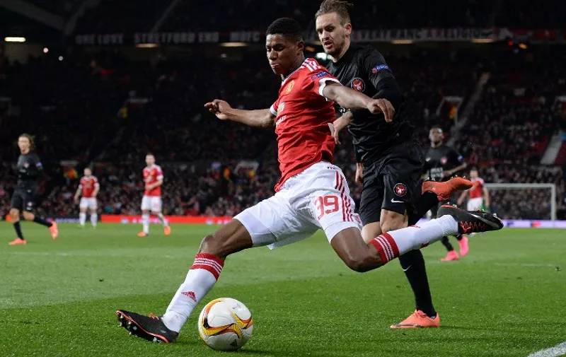 Manchester United's English striker Marcus Rashford (L) vies with FC Midtjylland's Danish defender Kian Hansen during the UEFA Europa League round of 32, second leg football match between Manchester United and and FC Midtjylland at Old Trafford in Manchester, north west England, on February 25, 2016.
Manchester United won the match 5-1. / AFP / OLI SCARFF