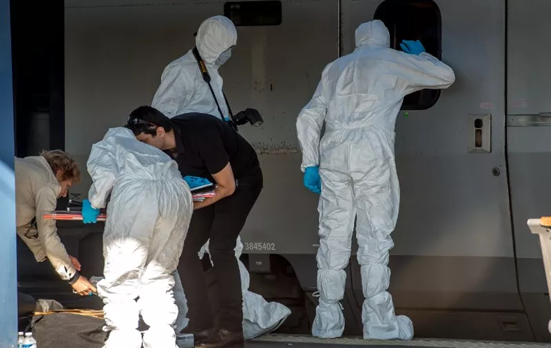 French forensics police officers wearing protective suits inspect the crime scene in a Thalys train of French national railway operator SNCF at the main train station in Arras, northern France, on August 22, 2015, a day after an armed gunman on the train was overpowered by passengers. The gunman opened fire on the train travelling from Amsterdam to Paris, injuring two people before being tackled by several passengers including off-duty American servicemen. AFP PHOTO / PHILIPPE HUGUEN