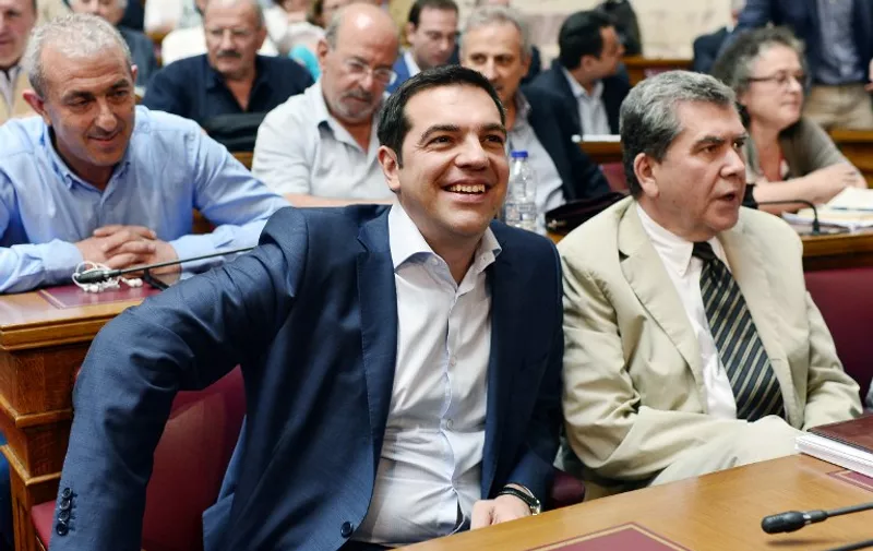 Greek Prime Minister Alexis Tsipras sits among his lawmakers during his parliamentray group meeting at the Greek Parliament in Athens on June 16, 2015. Tsipras charged the International Monetary Fund had "criminal responsibility" for Greece's debt crisis and called on the country's European creditors to assess the IMF's policies.   AFP PHOTO / LOUISA GOULIAMAKI
