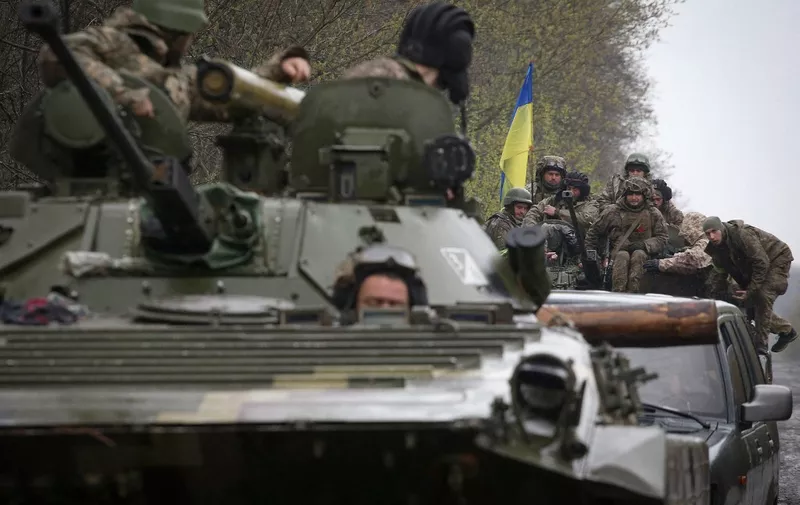 Ukrainian soldiers stand on their armoured personnel carrier (APC), not far from the front-line with Russian troops, in Izyum district, Kharkiv region on April 18, 2022, during the Russian invasion of Ukraine. (Photo by Anatolii Stepanov / AFP)