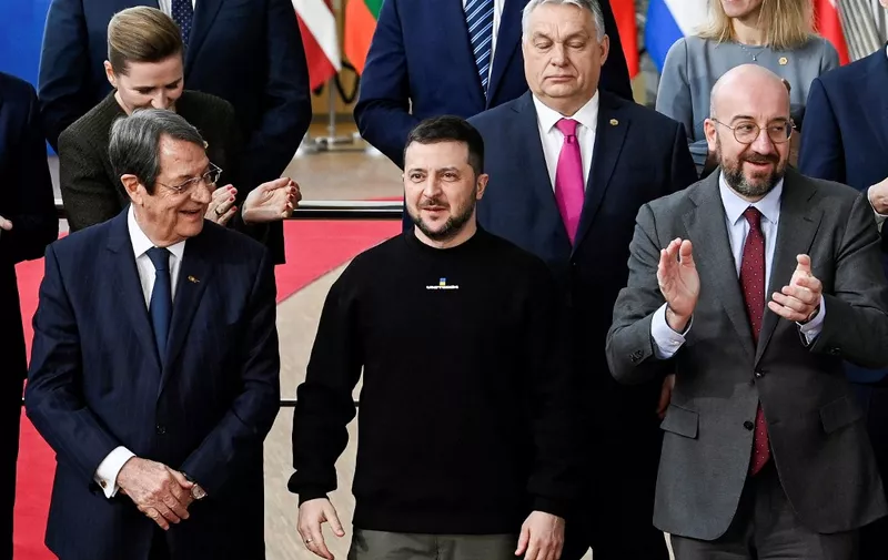 Ukraine's president Volodymyr Zelensky (C) is applauded by President of the European Council Charles Michel (R) next to Cyprus' President of the Republic Nikos Anastasiades (L) and Hungary's Prime Minister Viktor Orban (2ndR) as EU leaders gather for a family picture ahead of a summit in Brussels, on February 9, 2023. - Ukraine's President is set to attend an EU summit in Brussels on February 9, 2023, as the guest of honour where he will press allies to deliver fighter jets "as soon as possible" in the war against Russia. (Photo by JOHN THYS / AFP)