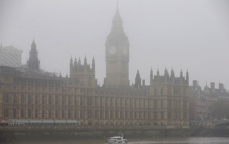 A boat travels along the River Thames through the fog past the Houses of Parliament in central London on November 2, 2015. Thick fog across much of Britain caused travel disruption on November 2, 2015 with 10 percent of flights cancelled from London Heathrow, Europe's busiest airport. AFP PHOTO / JUSTIN TALLIS