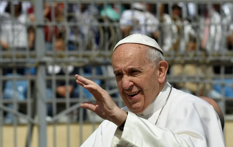 Pope Francis waves to worshippers before the start of a mass on April 29, 2017 at a stadium in Cairo. 
Pope Francis is set to lead a mass for Egypt's small Catholic community as he visits the country in support of its Christians following a series of deadly church bombings. The spiritual leader of the world's almost 1.3 billion Catholics will lead mass for some 30,000 believers in a stadium on the outskirts of Cairo.
 / AFP PHOTO / Andreas SOLARO