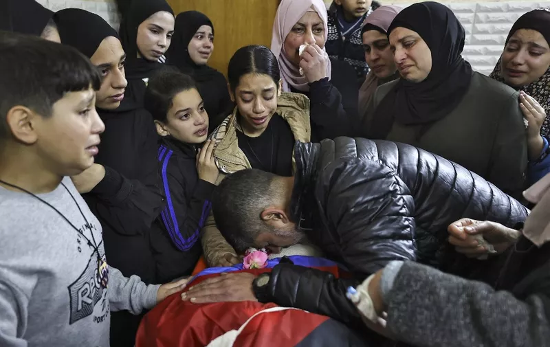 Relatives mourn over the body of a man killed during an overnight Israeli raid on the Tulkarem refugee camp in the occupied West Bank on January 9, 2024, amid continuing battles between Israel and the Palestinian militant group Hamas in Gaza. (Photo by Zain JAAFAR / AFP)