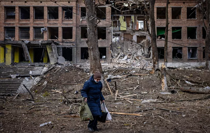 A woman walks in front of a destroyed building after a Russian missile attack in the town of  Vasylkiv, near Kyiv, on February 27, 2022. - Ukraine's foreign minister said on February 27, that Kyiv would not buckle at talks with Russia over its invasion, accusing President Vladimir Putin of seeking to increase "pressure" by ordering his nuclear forces on high alert. (Photo by Dimitar DILKOFF / AFP)