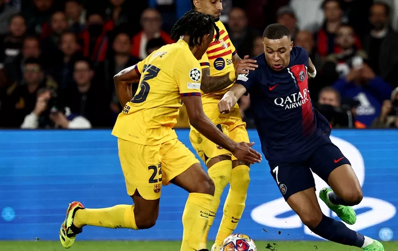 Paris Saint-Germain's French forward #07 Kylian Mbappe (R) fights for the ball with Barcelona's Brazilian forward #11 Raphinha (C) and Barcelona's French defender #23 Jules Kounde (L) during the UEFA Champions League quarter final first leg football match between Paris Saint-Germain (PSG) and FC Barcelona at the Parc des Princes stadium in Paris on April 10, 2024. (Photo by Anne-Christine POUJOULAT / AFP)